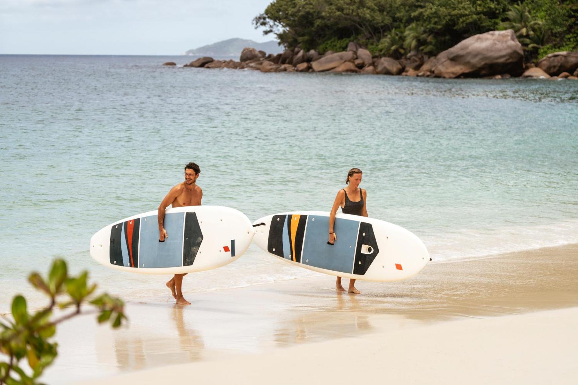Constance Lemuria Grand Anse  Exterior photo Stand up paddle boarders on a beach